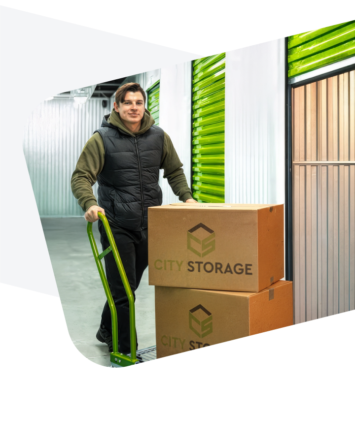 Aurimas Valujavičius su vežimėliu veža dėžes į City Storage sandėliuką.